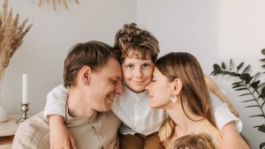 A joyful family moment with parents and their son embracing indoors.